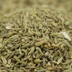 Gros plan sur graines de fenouil séchées vert clair et beige en vrac.