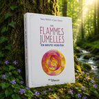 Livre Les Flammes Jumelles en Route vers Soi sur mousse sacrée au pied d'un arbre, entouré de fleurs violettes sous des rayons de soleil magiques.