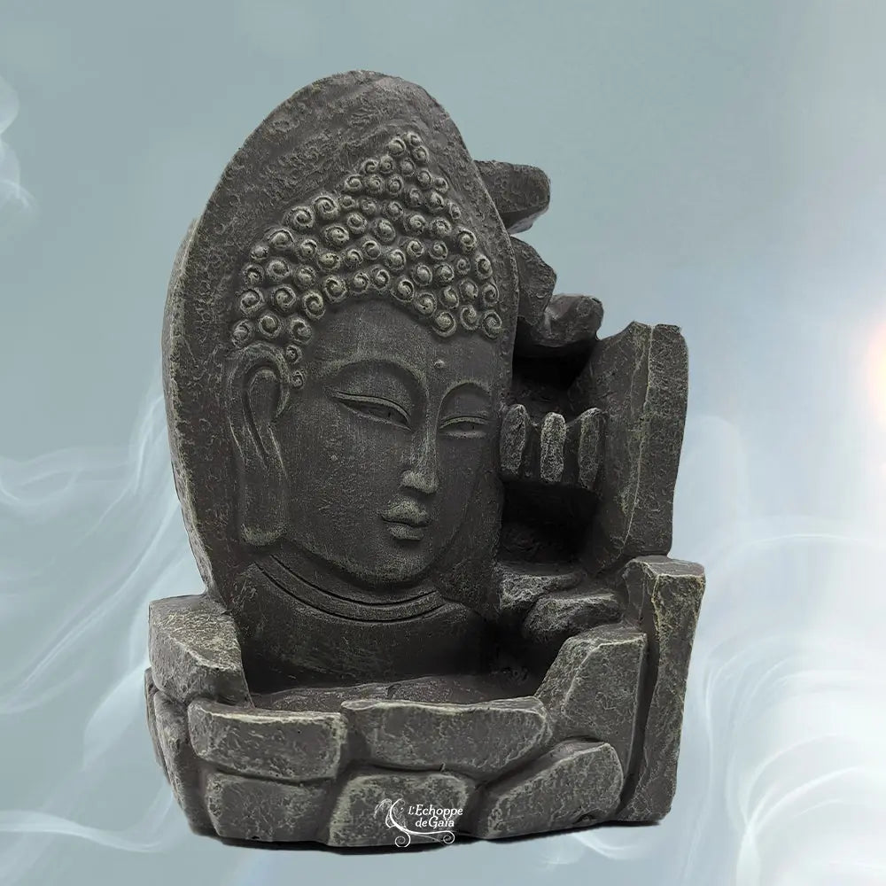 Porte-encens backflow gris anthracite effet pierre, visage de Bouddha et rochers, sur fond bleu fumé, logo « L’Echoppe de Gaïa ».
