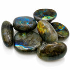 Labradorite - Galet, illustré par un ensemble de galets polis aux reflets métalliques changeants, allant du bleu profond au vert et à l'or brillant.