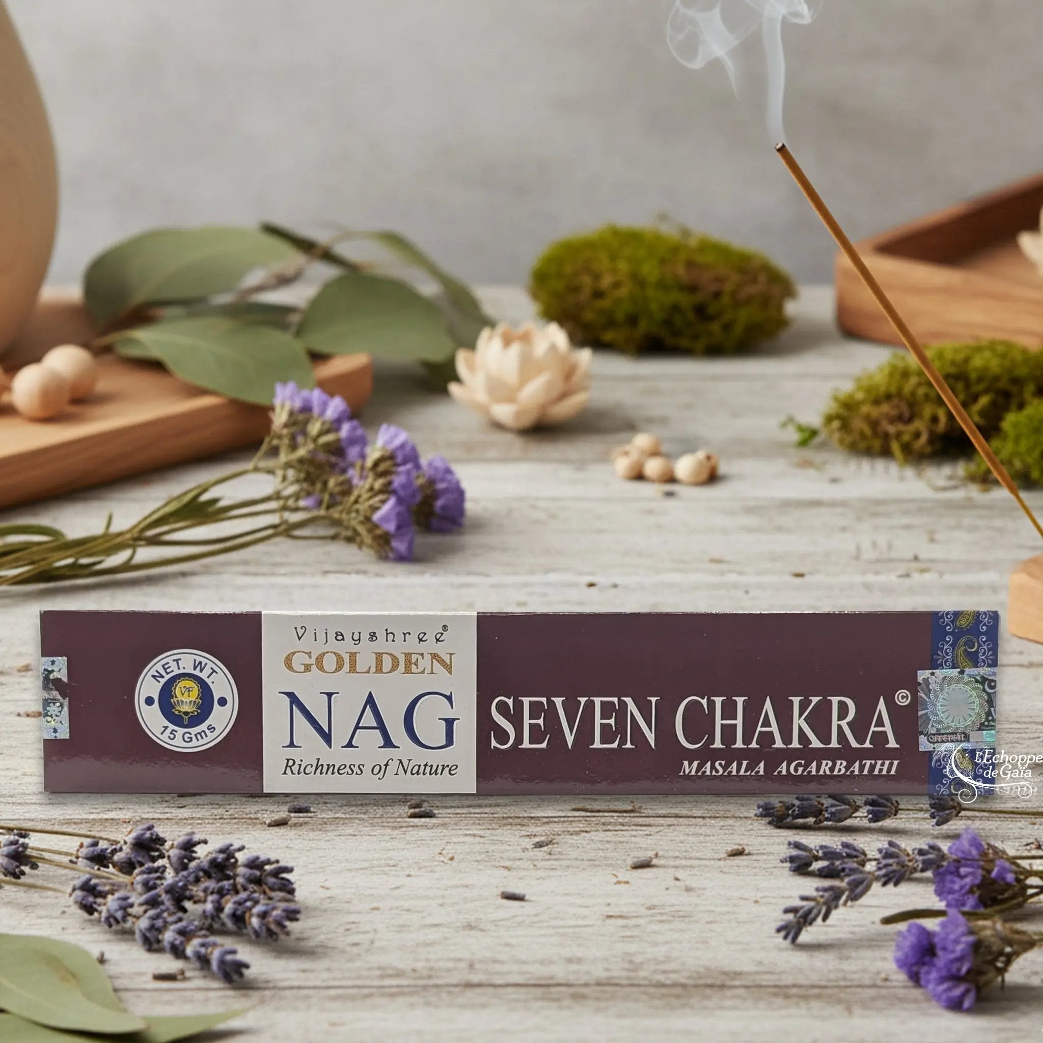 Boîte d'encens Vijayshree Golden Nag "Seven Chakra" Masala Agarbathi, posée sur une table avec de la lavande et un bâton d'encens fumant.