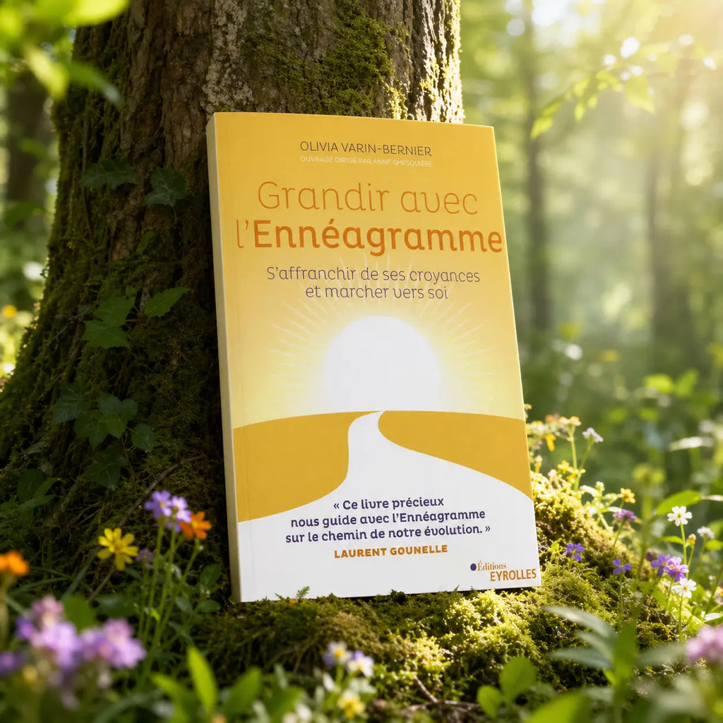 Livre jaune Grandir avec l'Ennéagramme d'Olivia Varin-Bernier contre un arbre, illustré par un chemin menant vers un soleil levant.