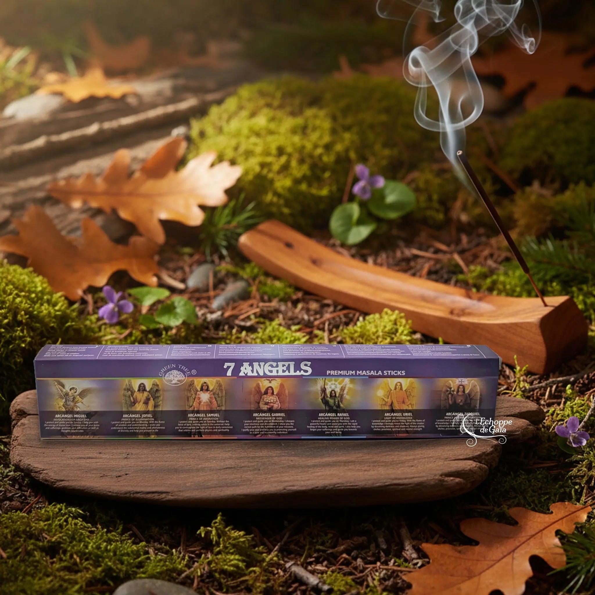Boîte d’encens Green Tree “7 Angels” posée sur un support en bois dans un décor de sous-bois automnal, avec un porte-encens en bois au fond d’où s’élève une volute de fumée.