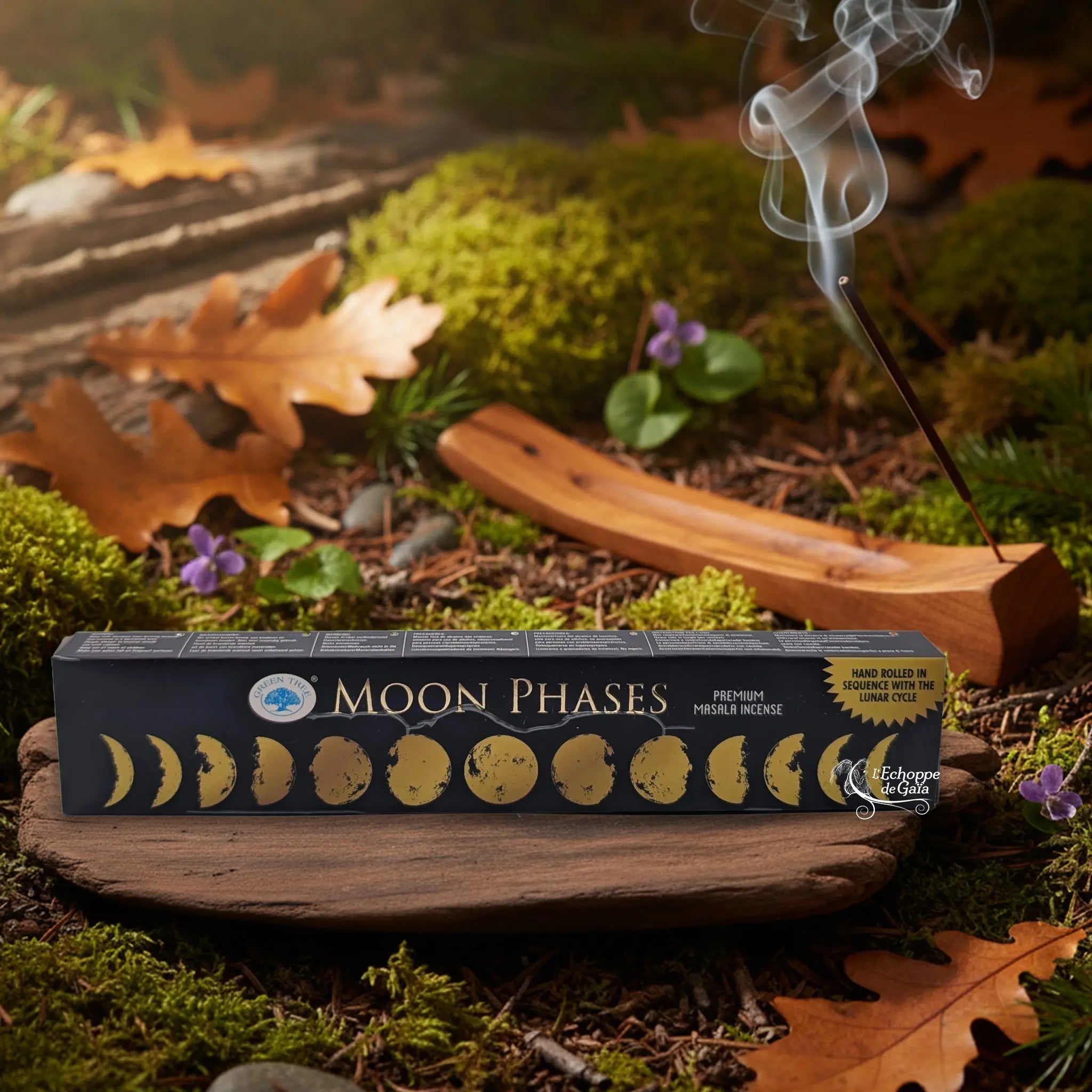 Boîte d’encens « Moon Phases » Green Tree posée sur un lit de mousse en forêt, avec porte-encens en bois fumant à l’arrière-plan.