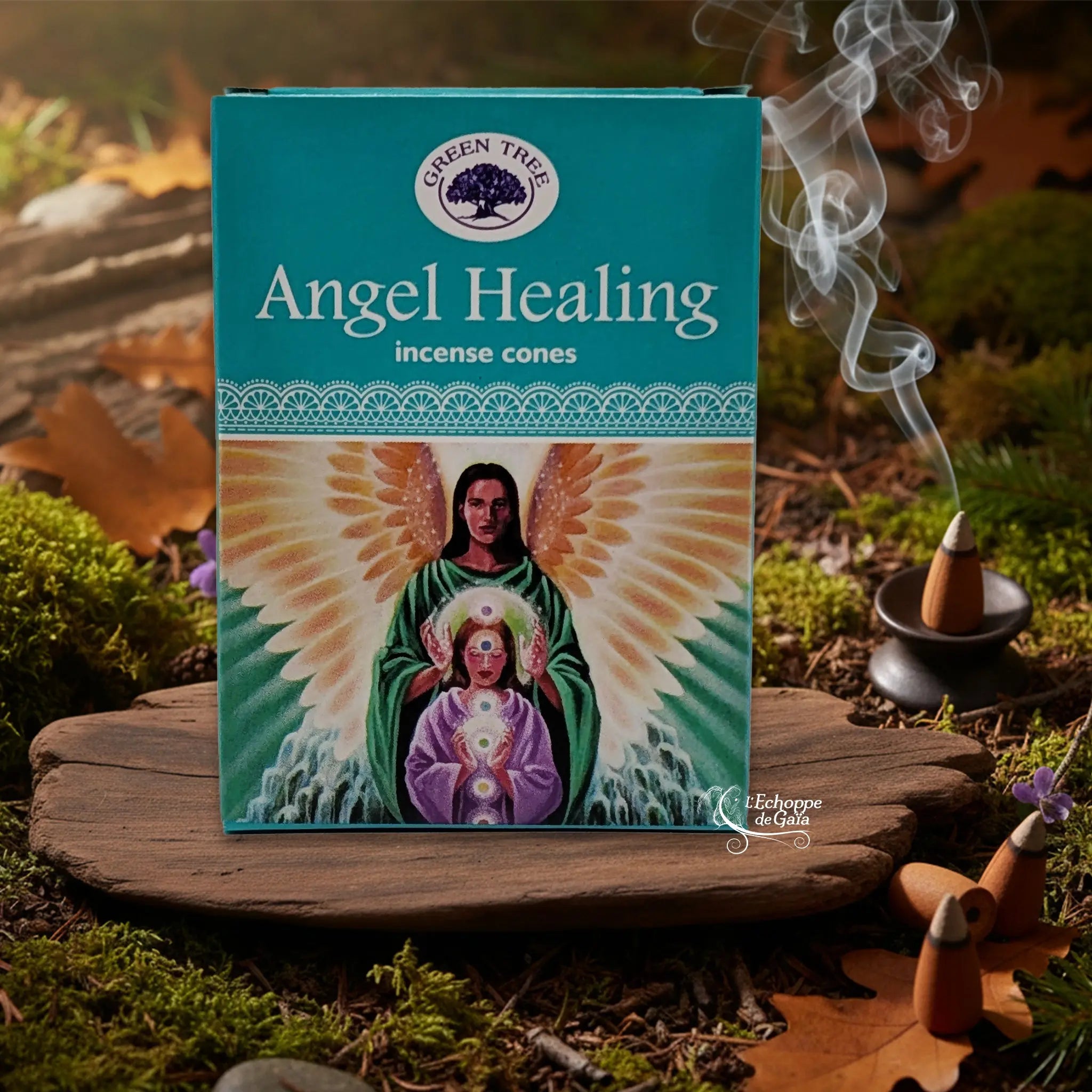 Boîte d’encens en cônes « Angel Healing » Green Tree posée sur une planche de bois en décor de sous-bois, avec cône fumant sur porte-encens à droite.