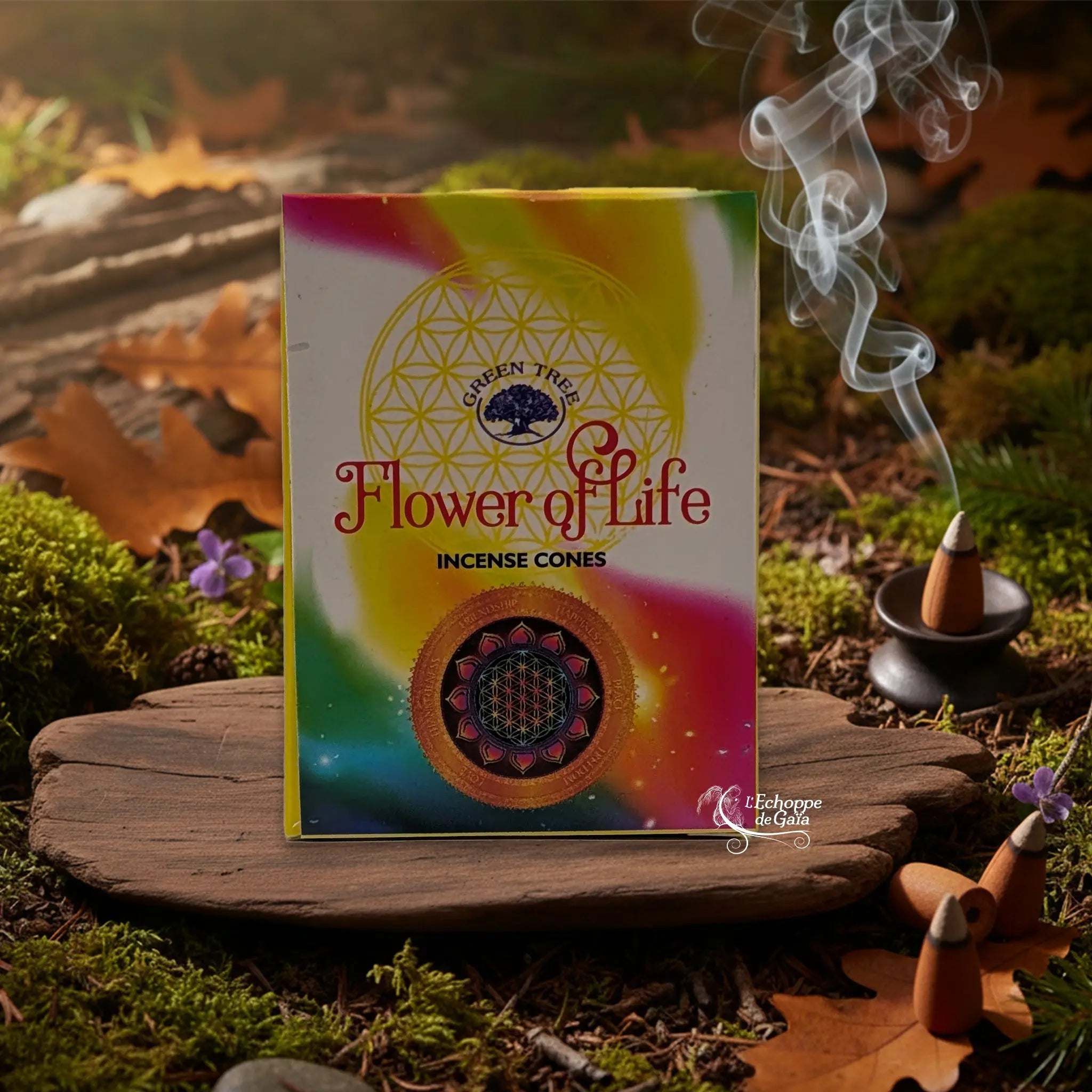 Boîte d’encens en cônes « Flower of Life » Green Tree posée sur une planche de bois en décor de sous-bois, avec cône fumant sur porte-encens à droite.