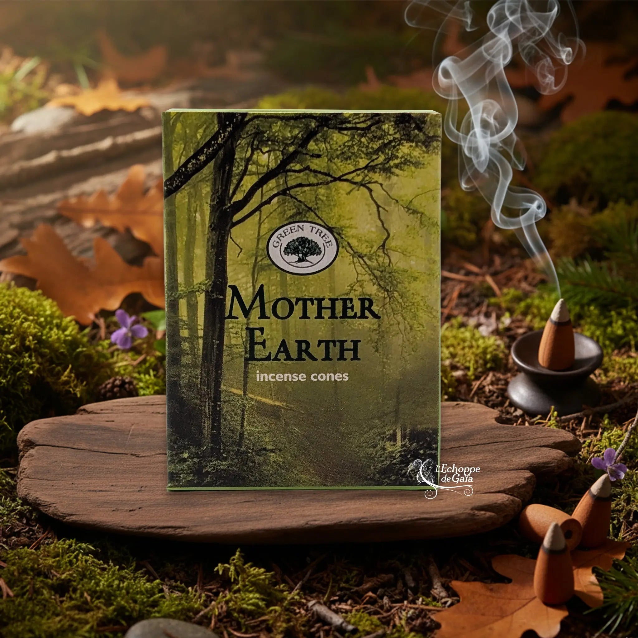 Boîte d’encens en cônes « Mother Earth » Green Tree posée sur une planche de bois en décor de sous-bois, avec cône fumant sur porte-encens à droite.