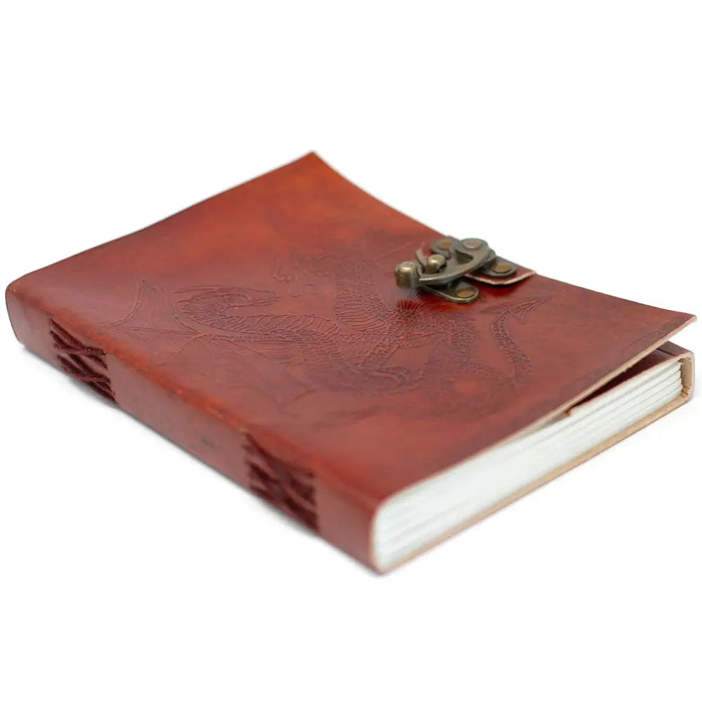 Un carnet grimoire en cuir marron clair embossé d'un motif de dragon, fermé par un loquet métallique en laiton et doté d'une reliure artisanale à lacets assortis sur fond blanc.