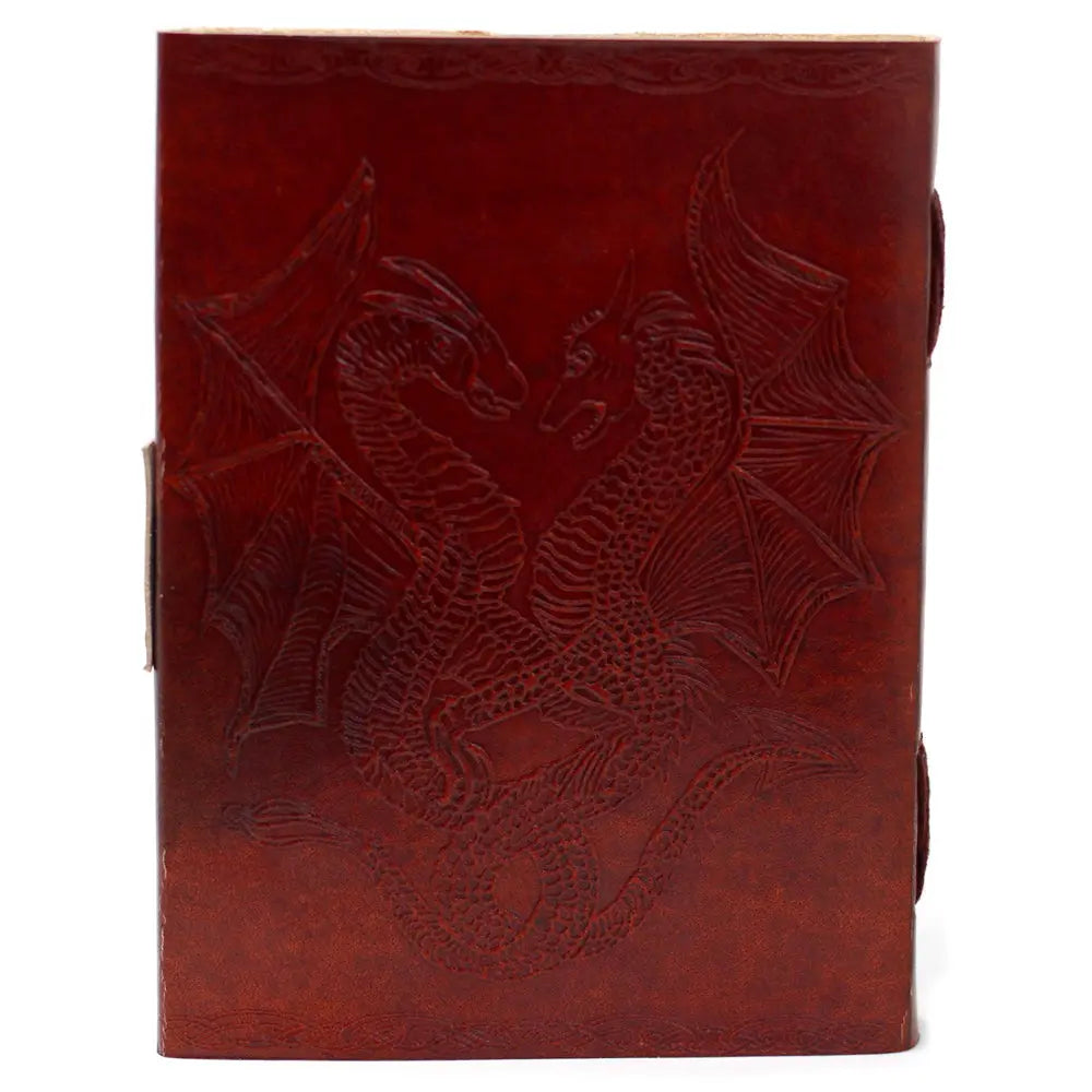 La couverture d'un carnet grimoire en cuir marron clair présentant un motif de deux dragons ailés face à face, finement embossé de manière symétrique avec des bordures ciselées.
