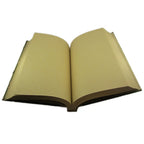Un carnet grimoire ouvert révélant des pages vierges en papier artisanal de couleur crème, avec une couverture végétale verte visible sur les bords, sur fond blanc.