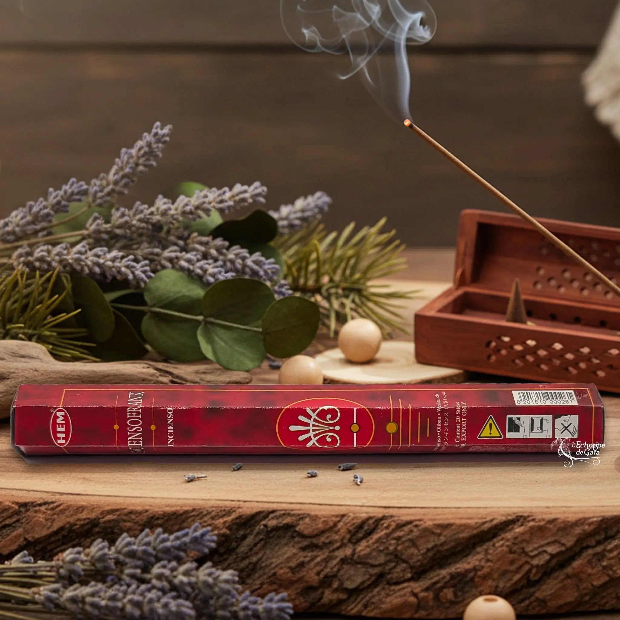 Boîte d'encens HEM "Precious Frankincense" posée sur du bois avec de la lavande et un bâton d'encens fumant.