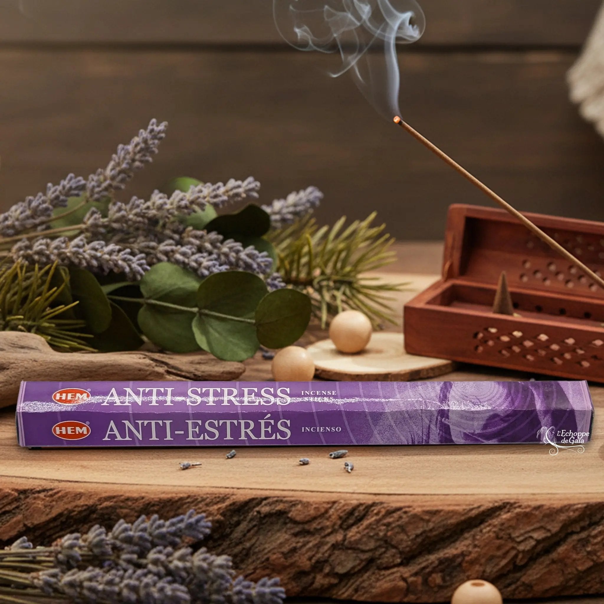 Boîte d'encens HEM "Anti-Stress / Anti-Estrés" posée sur du bois avec de la lavande et un bâton d'encens fumant.