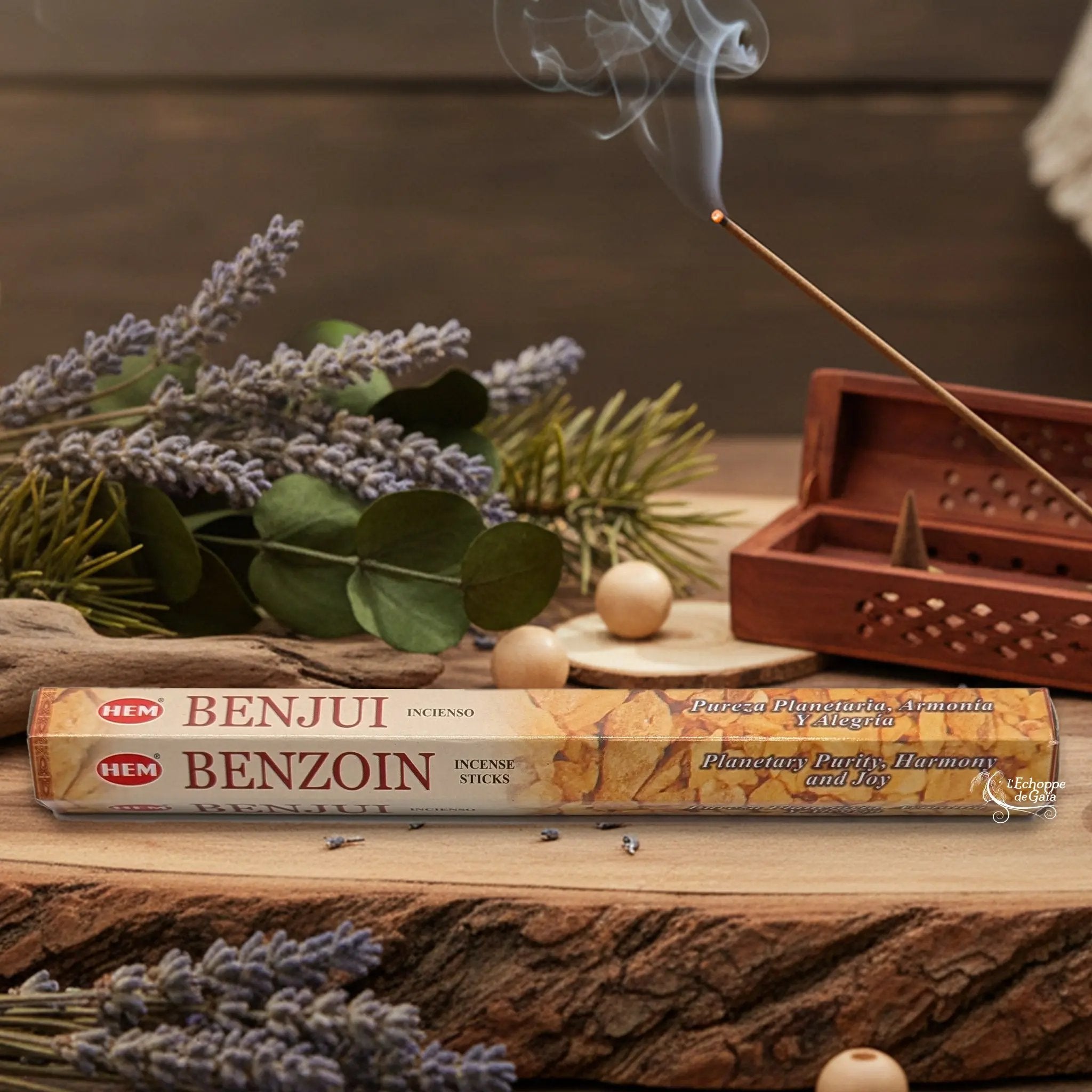 Boîte d'encens HEM "Benzoin / Benjui" posée sur du bois avec de la lavande et un bâton d'encens fumant.
