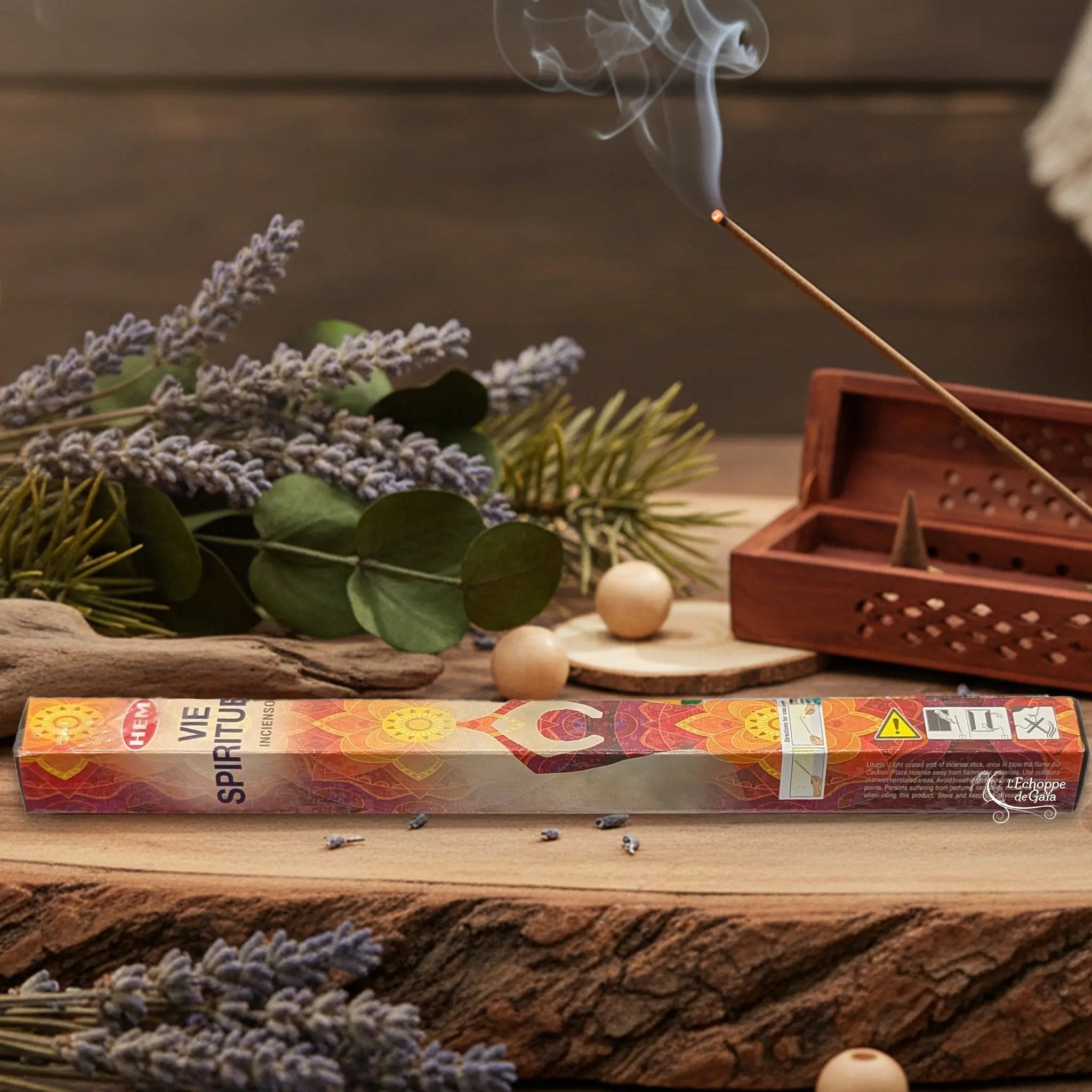 Boîte d'encens HEM "Vie Spirituelle" posée sur du bois avec de la lavande et un bâton d'encens fumant.