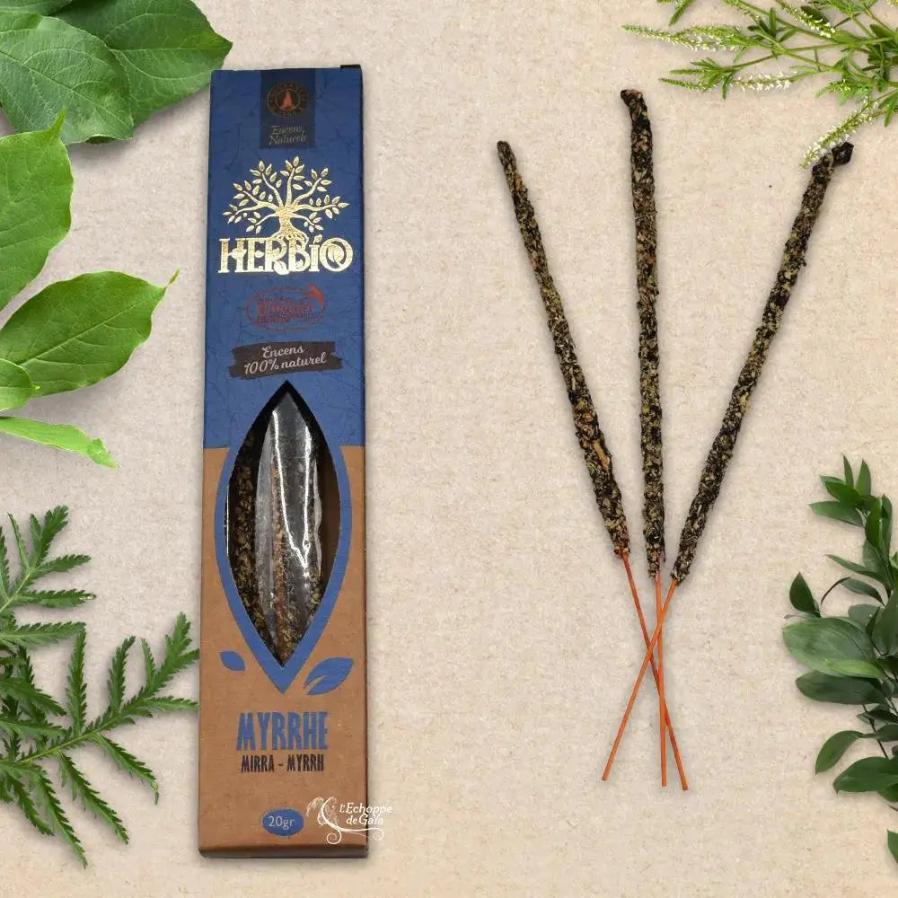 Boîte d'encens Herbio Myrrhe naturel bleu avec trois bâtonnets à tige orange sur fond beige et feuilles vertes