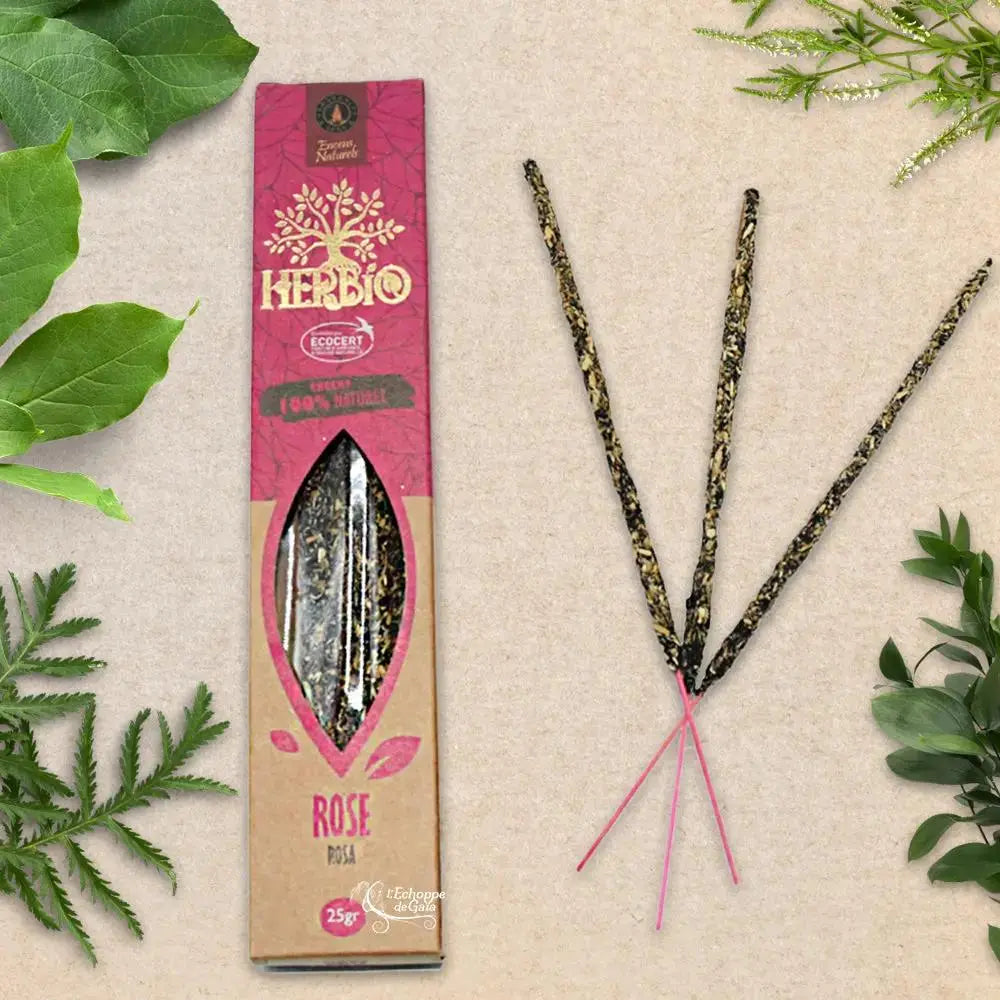 Boîte d'encens Herbio Rose naturel rouge avec trois bâtonnets à tige rose sur fond beige et feuilles vertes