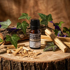 Huile essentielle de palo santo 10 ml, flacon ambré avec bouchon noir posé sur rondin de bois avec éclats et bâtons de palo santo.