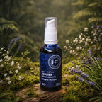 Flacon bleu à pompe d'Huile Végétale Jojoba Rééquilibrante Herbes et Traditions posé sur une souche moussue dans une forêt baignée de lumière.