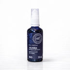 Un flacon pompe de 50 ml d'huile végétale de jojoba bio rééquilibrante de la marque Herbes & Traditions, en verre bleu foncé avec une étiquette assortie, présenté sur un fond blanc.