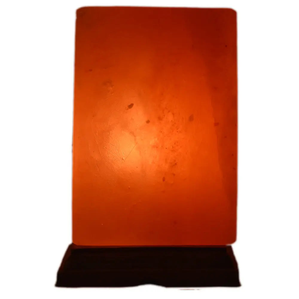 Lampe en véritable Sel de l'Himalaya - Forme Rectangle, illustrée par un bloc de sel rectangulaire taillé de manière géométrique, diffusant une lumière chaleureuse et ambrée depuis son socle en bois sombre.