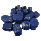 Un ensemble de pierres de lapis-lazuli roulées d'un bleu profond, parsemées d'éclats de pyrite dorée et de marbrures blanches, regroupées sur un fond blanc uni.