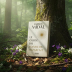 Livre Le Guide du Bonheur Imparfait de Fabrice Midal posé contre un arbre en forêt, baigné de rayons de soleil et entouré de fleurs sauvages.