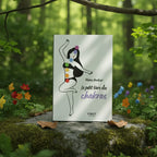 Livre blanc Le Petit Livre des Chakras d'Héloïse Amilcar posé sur un rocher en forêt, couverture illustrée d'une silhouette féminine avec les 7 chakras colorés.