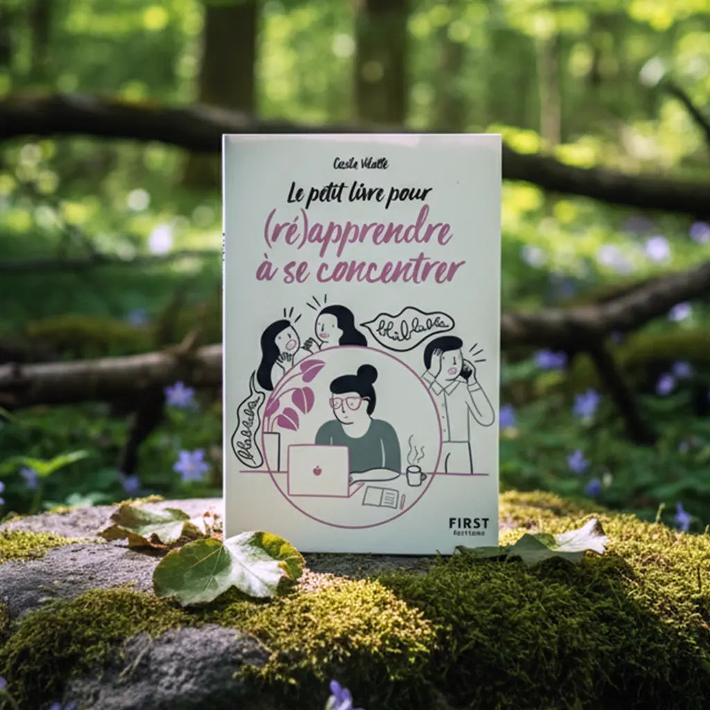 Livre Le Petit Livre pour (ré)apprendre à se Concentrer - Cécile Vilatte posé sur un rocher moussu en forêt, illustré d'une femme au travail cherchant le calme.