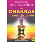 Les Chakras, roues de la vie de Anodea Judith, sa couverture illustrant une personne en posture de yoga sur laquelle sont alignés les sept chakras colorés, sur un fond dégradé violet et jaune lumineux.