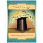 Carte oracle « Croire à la magie » représentant un chapeau de magicien d’où s’échappent des symboles et objets (oiseau, dauphin, notes, étoiles), avec la citation « Une véritable magie inonde ma vie ! ».