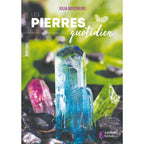 Couverture du livre "Les Pierres au quotidien" de Julia Boschiero, illustrée par plusieurs cristaux colorés (bleu, rose et vert) se dressant sur un lit de petites pierres sombres, éditée par Améthyste Éditions.