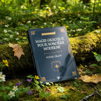Livre Magie Grecque pour Sorcière Moderne - Strix Craft posé en forêt, couverture bleue nuit ornée d'un chaudron doré et de symboles antiques.