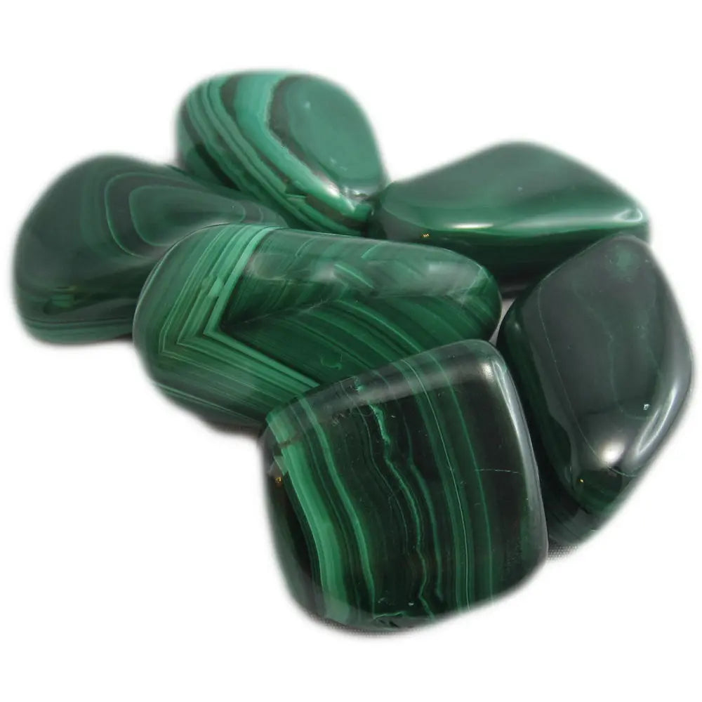 Plusieurs pierres de malachite polies, présentant des motifs rubanés et des strates de vert foncé, regroupées sur un fond blanc.
