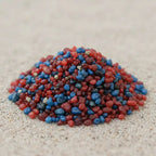 Gros plan sur un monticule de grains d'encens de résine Marie qui Défait les Noeuds, montrant un mélange dense de rouge vif, bleu royal et de bordeaux foncé.