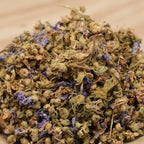 Gros plan sur des fleurs de mauve séchées, en petits boutons verts et pétales violets.