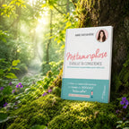 Livre Métamorphose, éveille ta conscience ! - Anne Ghesquière sur mousse sacrée au pied d'un arbre, entouré de fleurs violettes sous des rayons de soleil magiques.