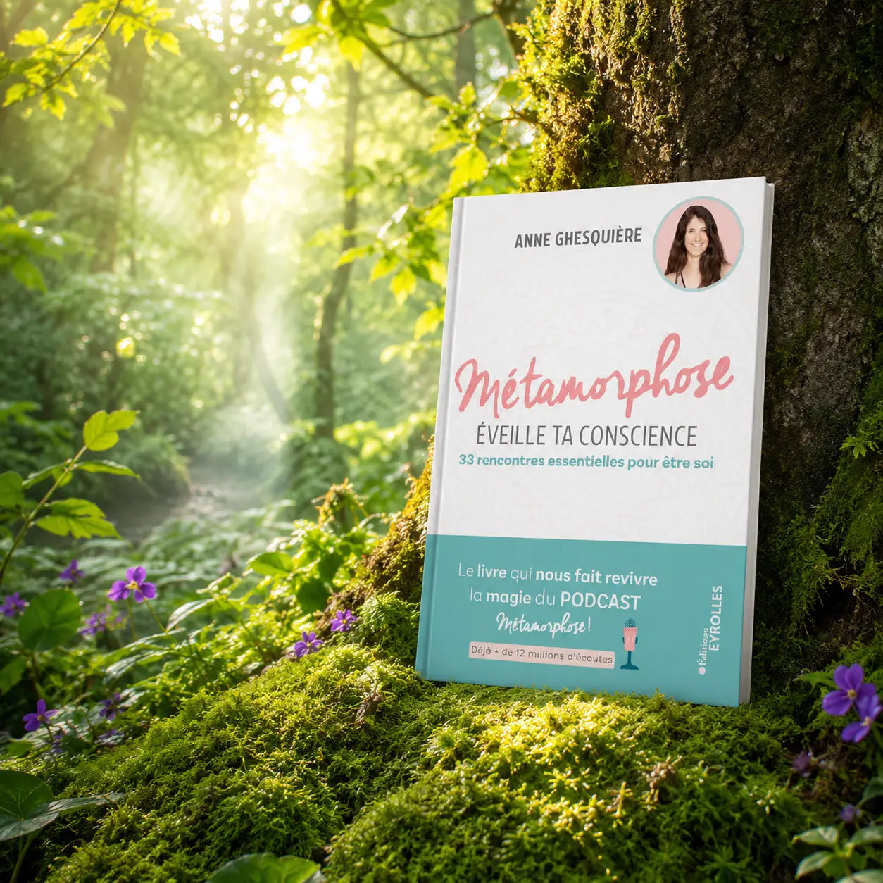 Livre Métamorphose, éveille ta conscience ! - Anne Ghesquière sur mousse sacrée au pied d'un arbre, entouré de fleurs violettes sous des rayons de soleil magiques.