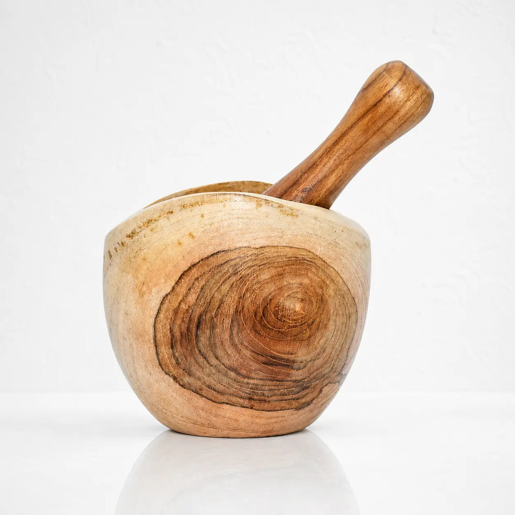 Mortier et pilon en teck : bol artisanal en bois clair mettant en valeur les cernes et les contrastes naturels du bois.