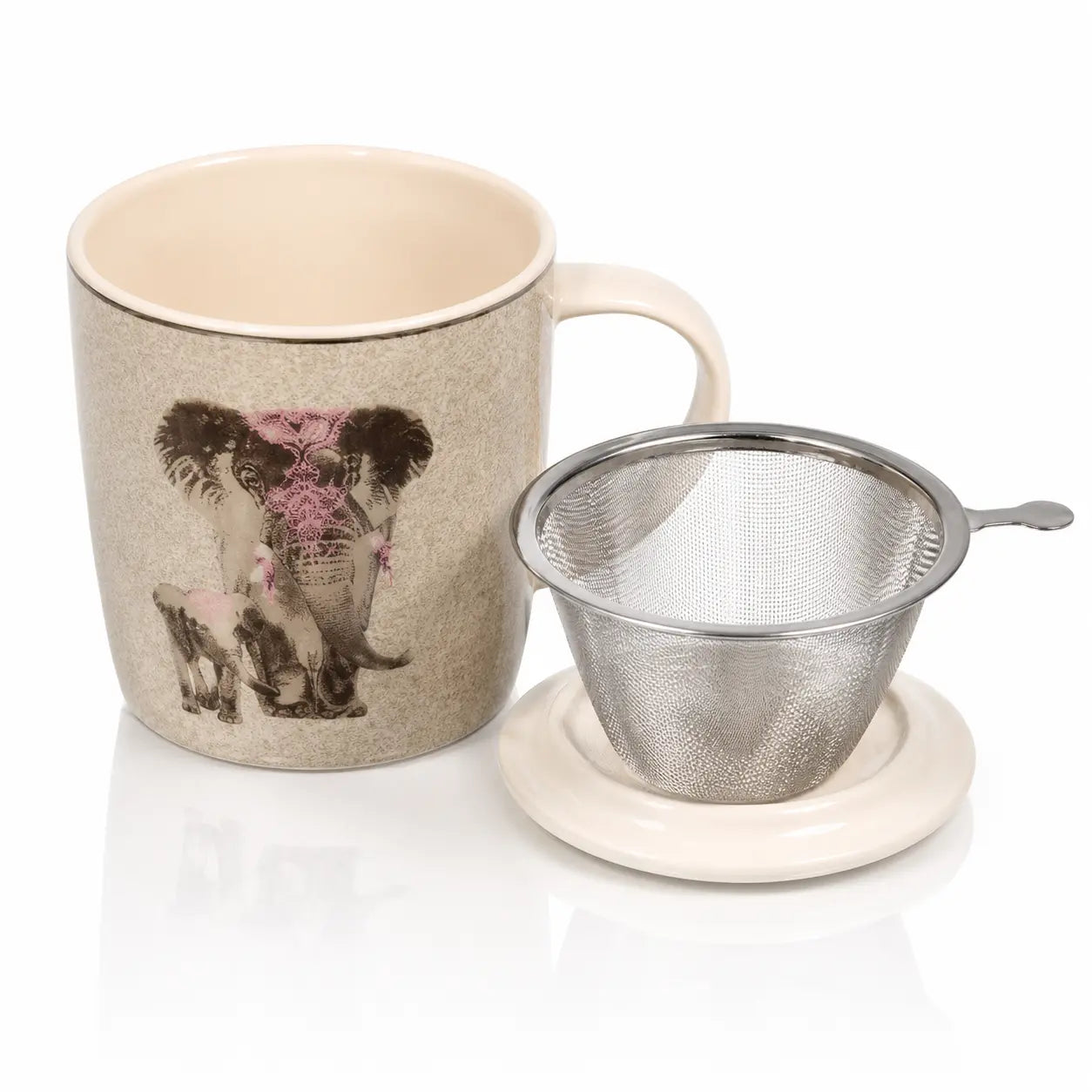 Tasse infuseur éléphant en porcelaine beige présentant un dessin d'éléphants, posée à côté de son filtre en acier inoxydable placé sur son couvercle blanc.