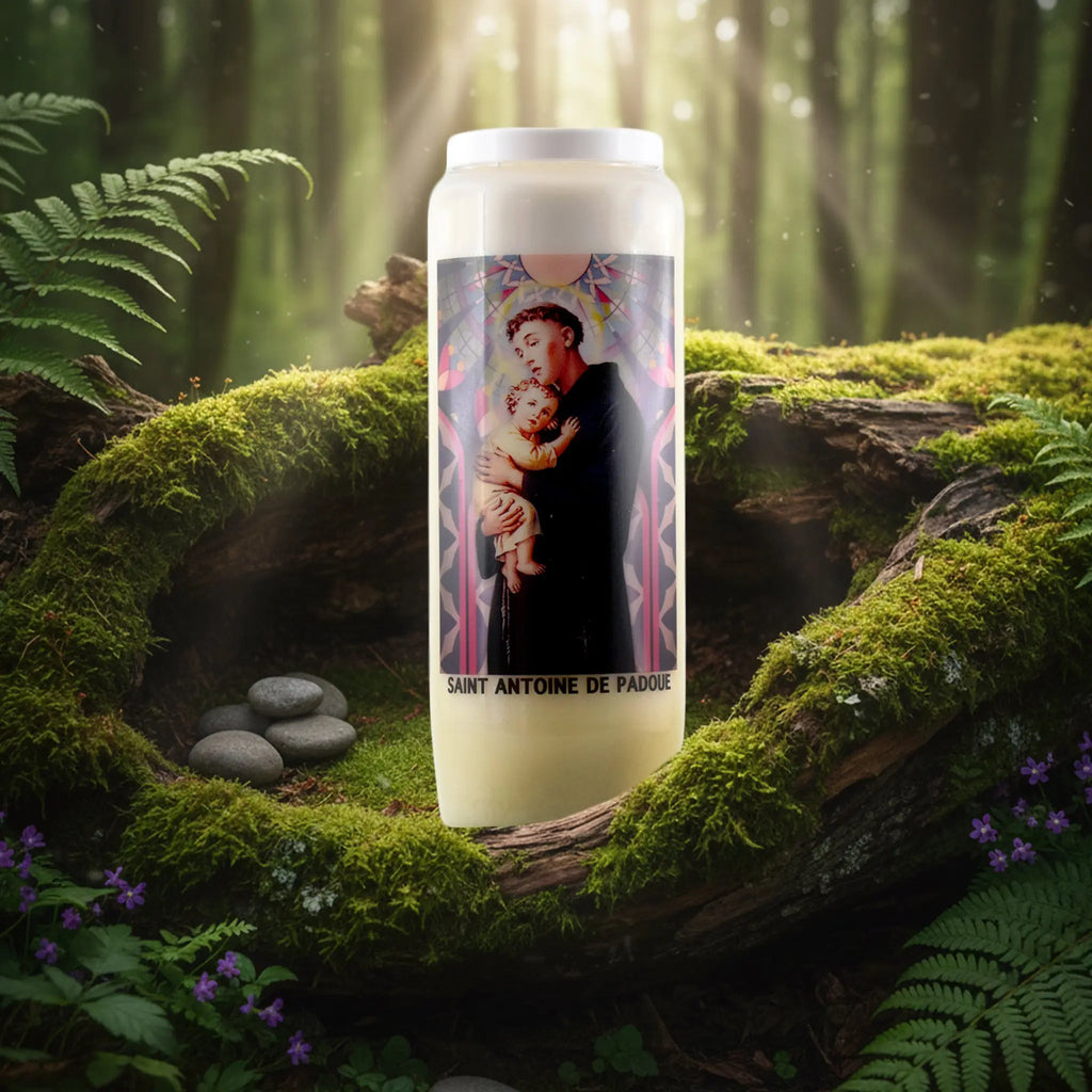 Bougie neuvaine Saint Antoine de Padoue avec illustration colorée, posée sur un lit de mousse en forêt.