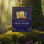 Coffret bleu et doré L'Oracle Fontaine d'Émilie Porte posé dans la mousse, illustré de trois cartes révélant un labyrinthe, un personnage solaire et une scène lunaire.