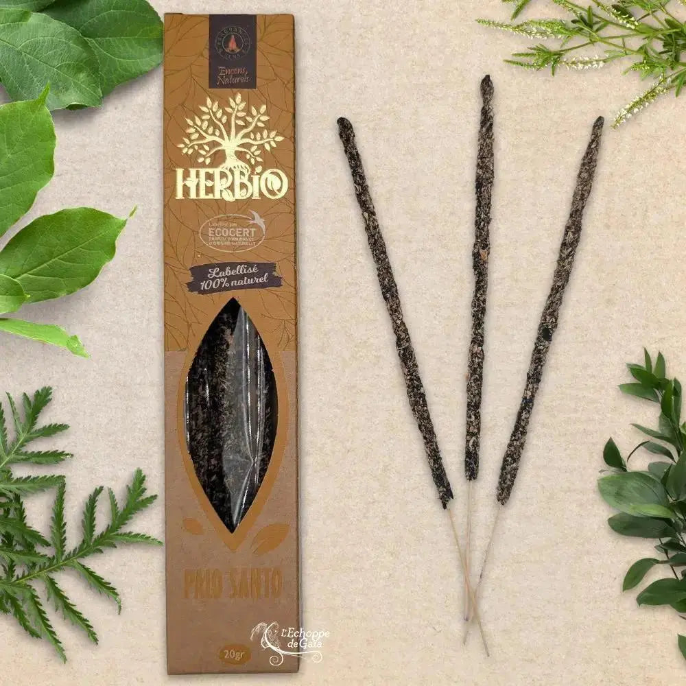 Boîte d'encens Herbio Palo Santo naturel marron avec trois bâtonnets à tige beige sur fond beige et feuilles vertes
