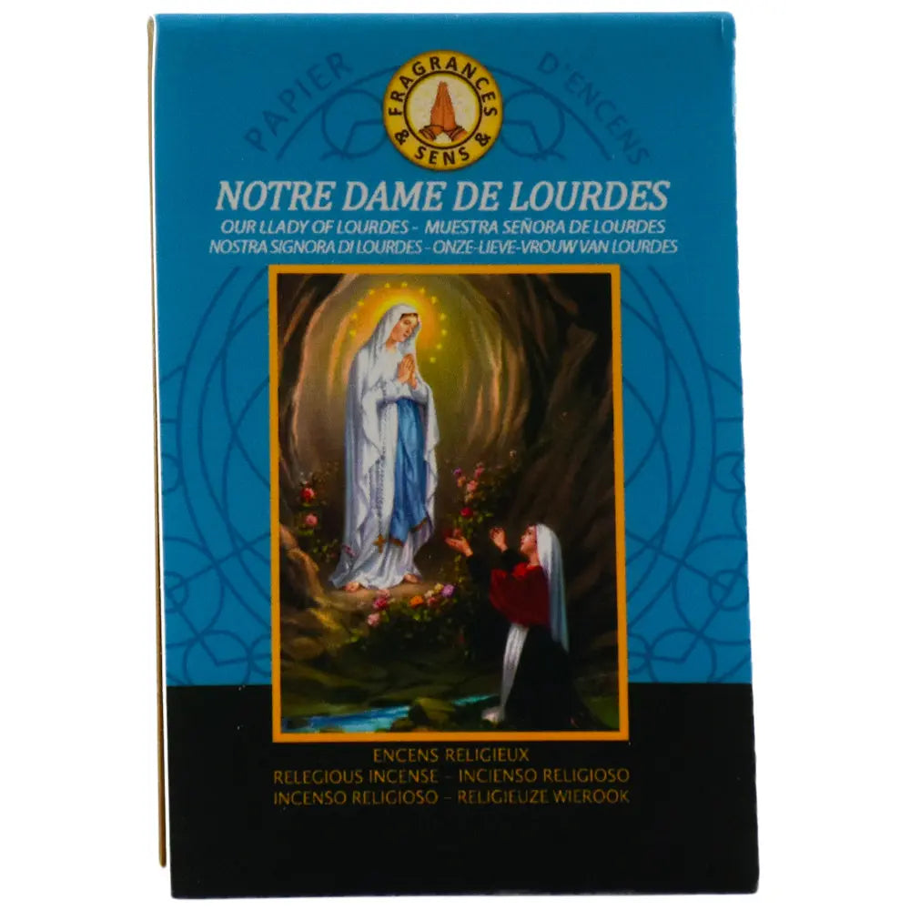 Ce carnet de papier d'encens Fragrances & Sens dédié à Notre Dame de Lourdes arbore une illustration classique de l'apparition de la Vierge Marie à Sainte Bernadette dans la grotte, sur un fond bleu turquoise et noir.
