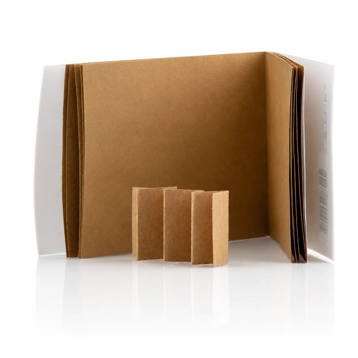 Ce visuel montre l'intérieur d'un carnet de papier d'encens Fragrances & Sens ouvert, dévoilant ses feuillets bruns prédécoupés, ainsi qu'une petite bande détachée et pliée en accordéon au premier plan.