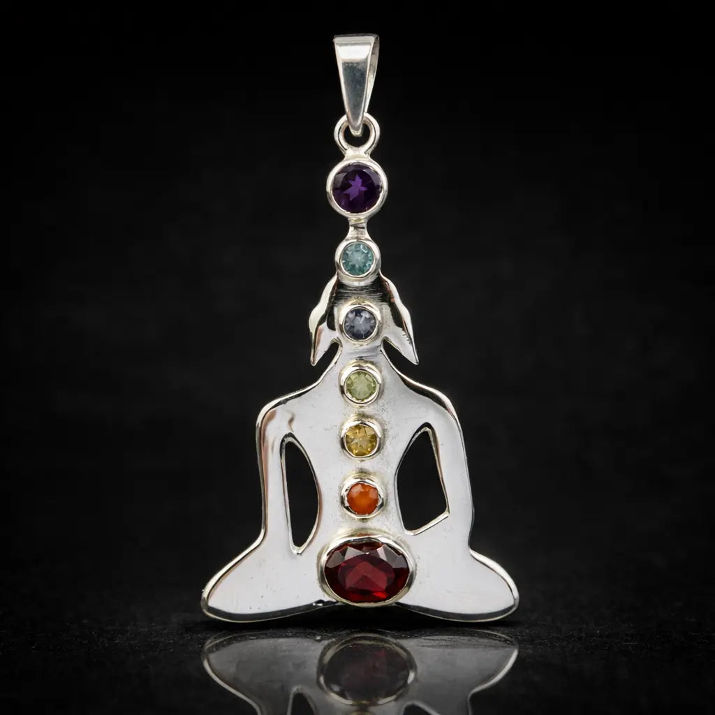 Un pendentif Bouddha en argent représentant les 7 chakras par l'alignement vertical de sept pierres naturelles de couleurs différentes, présenté sur un fond noir avec un reflet net.
