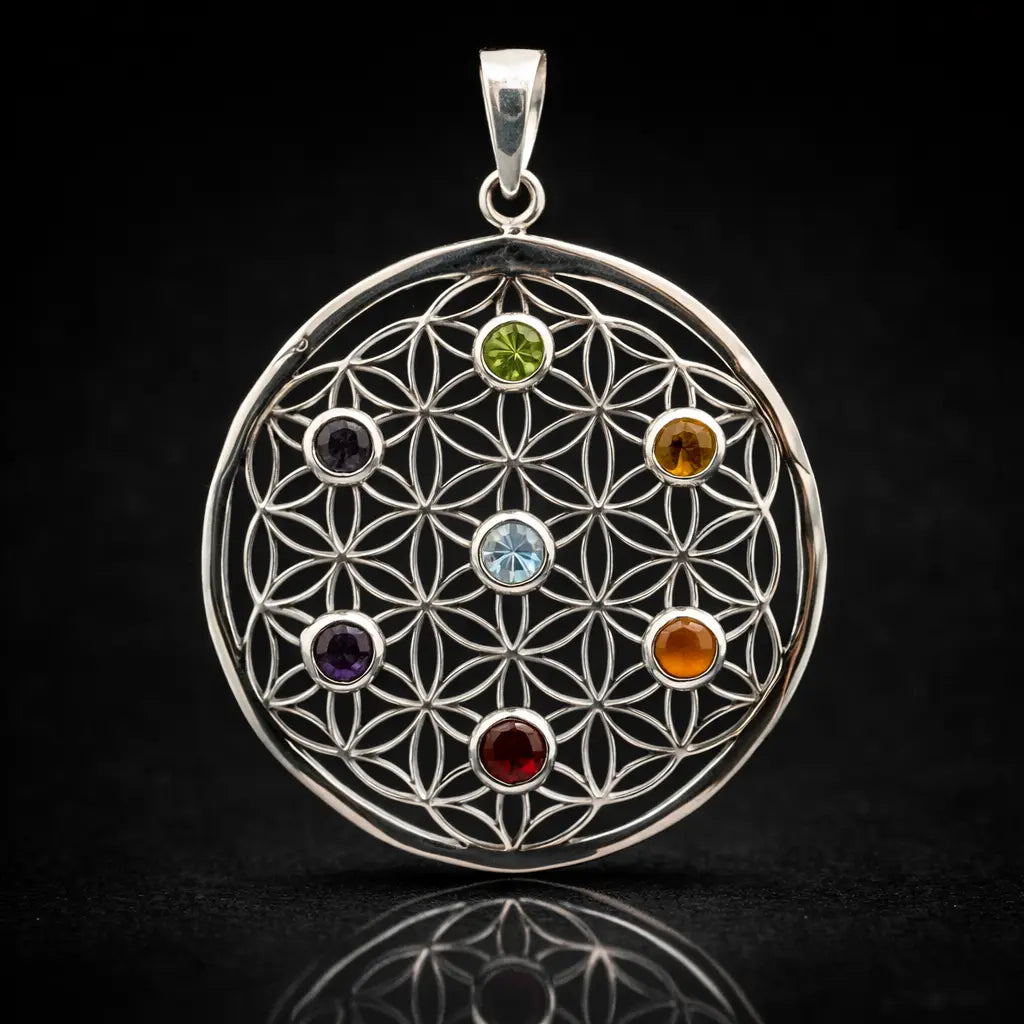 Un pendentif fleur de vie en argent orné de sept pierres naturelles circulaires représentant les 7 chakras, présenté sur un fond noir avec un reflet net à sa base.
