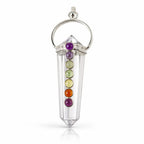 Un pendentif 7 chakras composé d'une pointe de cristal de roche taillée, ornée de sept petites pierres multicolores alignées et d'une monture en métal argenté, présenté sur un fond blanc.