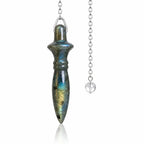 Pendule Thot labradorite en pierre naturelle polie aux reflets bleus et dorés, sculpté en forme d'amulette égyptienne et suspendu à une chaîne en métal argenté dotée d'une perle transparente.
