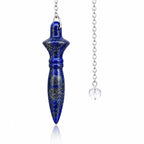 Pendule Thot lapis-lazuli en pierre naturelle bleu profond pailletée de doré, sculpté de motifs géométriques et suspendu à une chaîne argentée avec perle transparente.