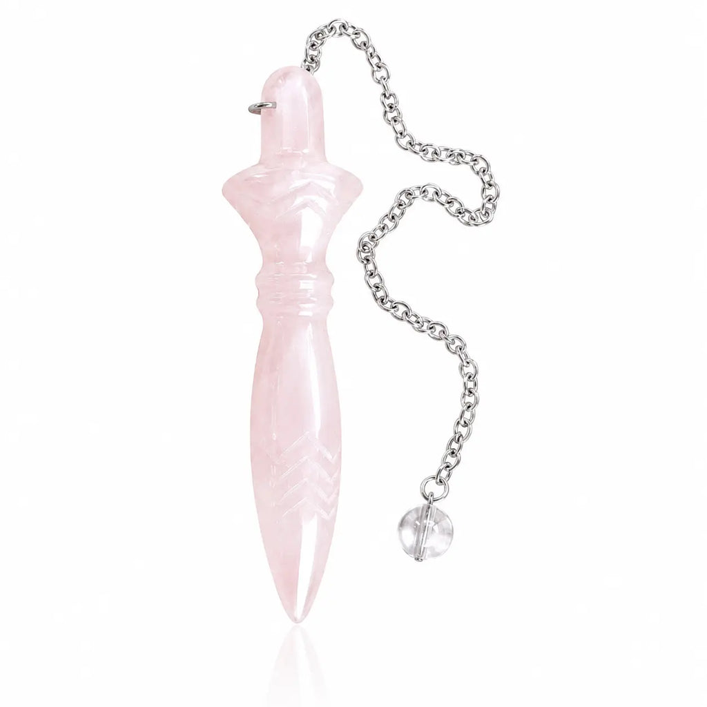 Pendule de Thot en quartz rose pastel sculpté, couché de profil sur fond blanc neutre avec sa chaînette métallique et sa perle en cristal.